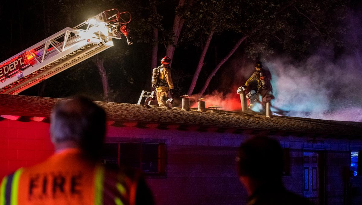 Firefighters work to contain a fire on the roof of the office at Flamingo Village Mobile Home Park July 4 in Pasco.