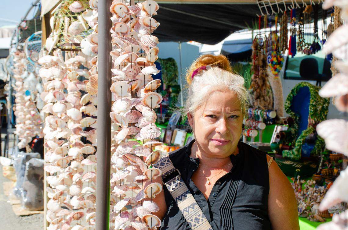 Paula Thompson, 61, of Yakima, poses for a photo at her canopy-covered spot at the Pasco Flea Market. She sells necklaces, dream catchers, fountains and sea shell wind chimes at the weekend market.