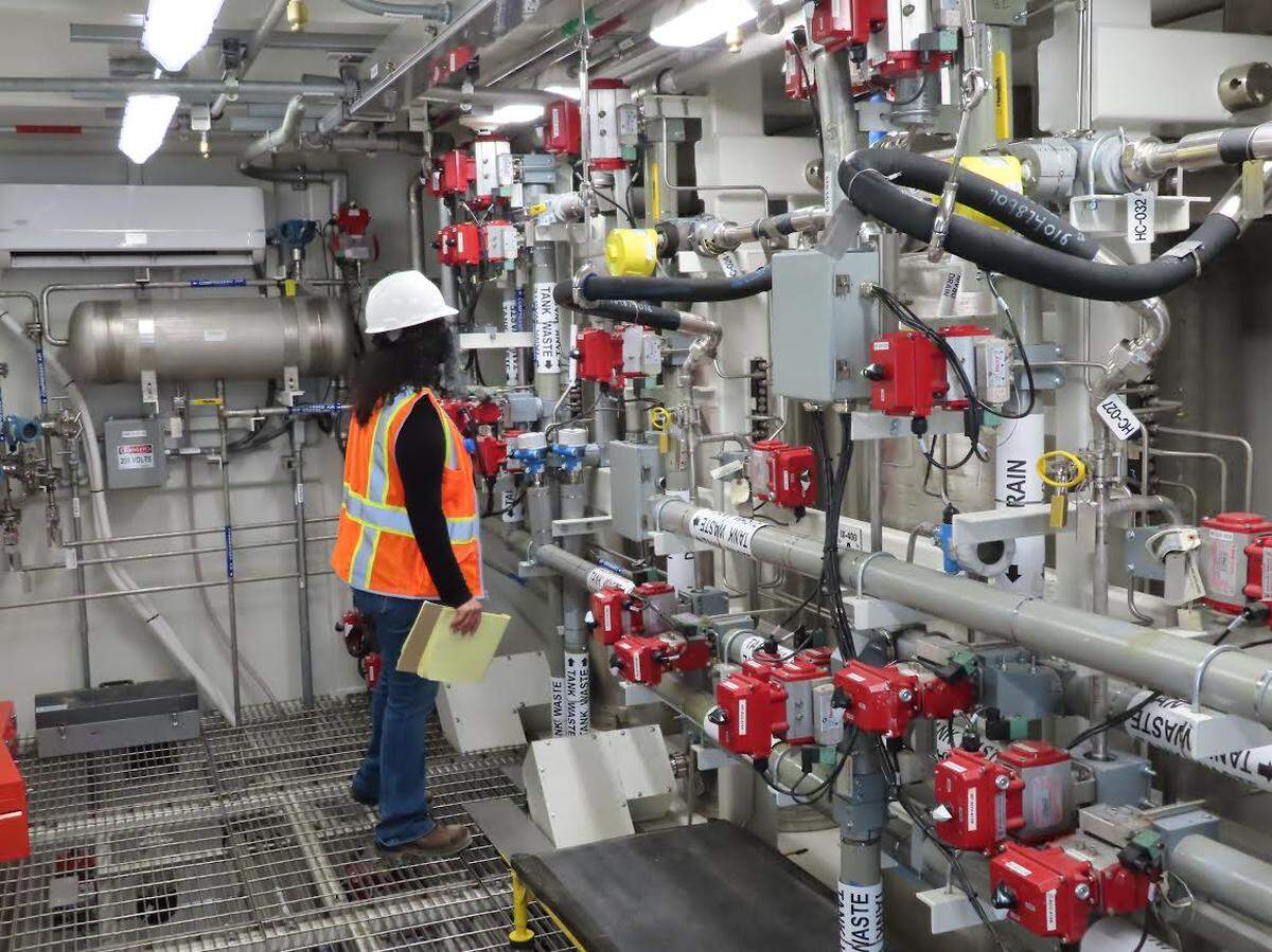 Nitya Chandran, Washington state Department of Ecology, takes a close look inside the Tank-Side Cesium Removal System’s process enclosure in September 2021.