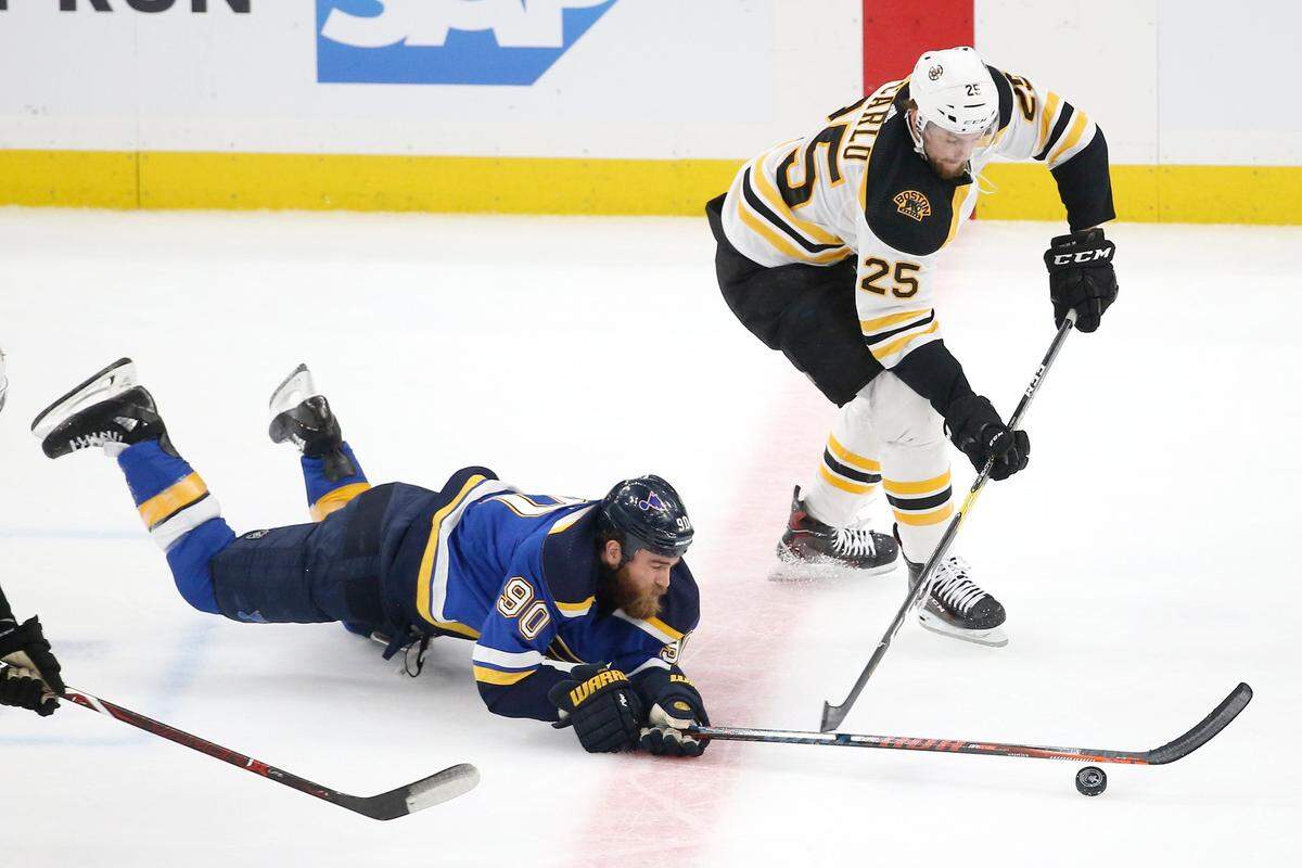 Boston Bruins defenseman Brandon Carlo (25) and St. Louis Blues center Ryan O’Reilly (90) chase the puck during the first period of Game 6 of the NHL hockey Stanley Cup Final on Sunday.