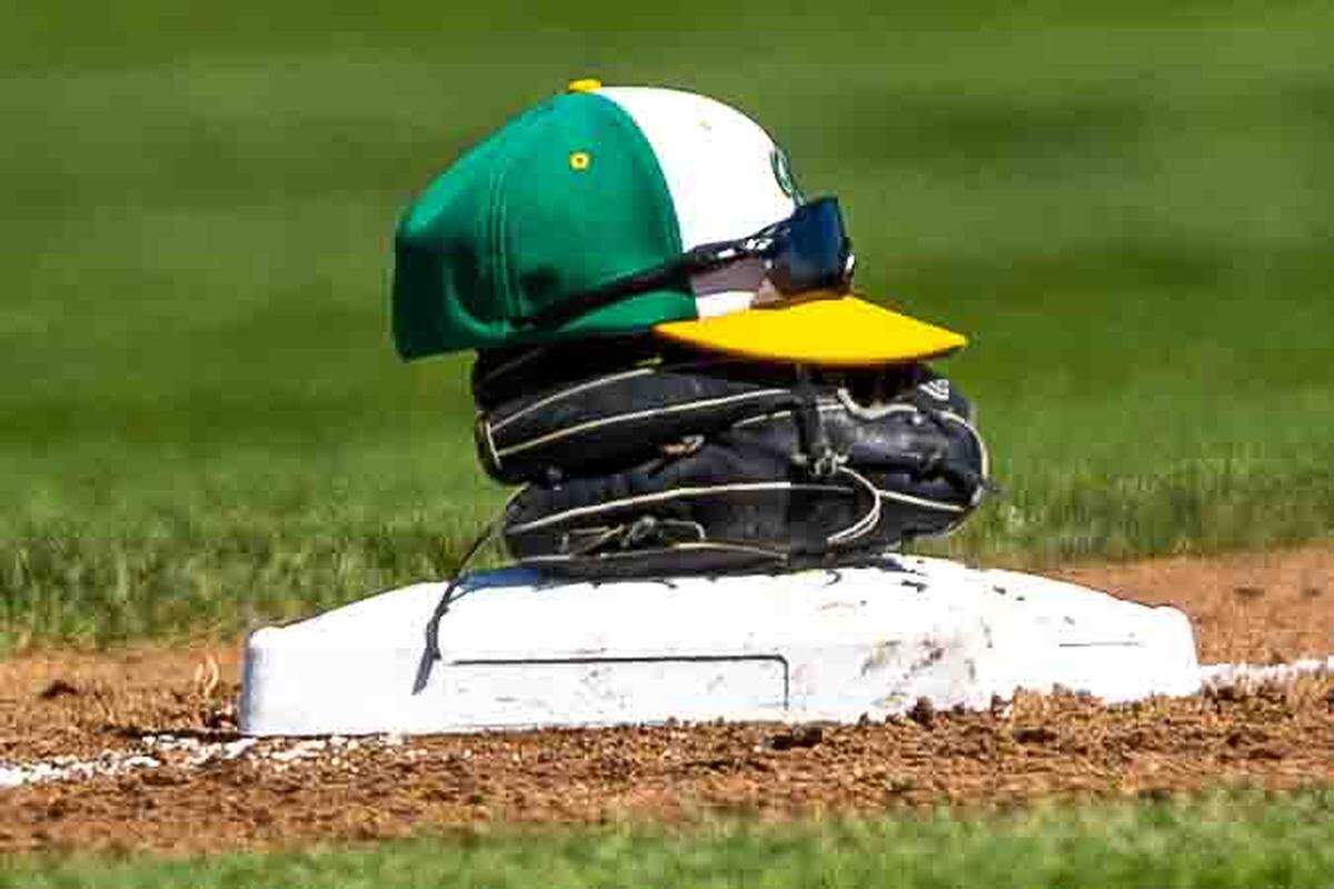 A Richland Bombers cap, glove and sunglasses rest atop second base between innings during the WIAA 4A State Baseball Championships Saturday at Bomber Bowl in Richland.