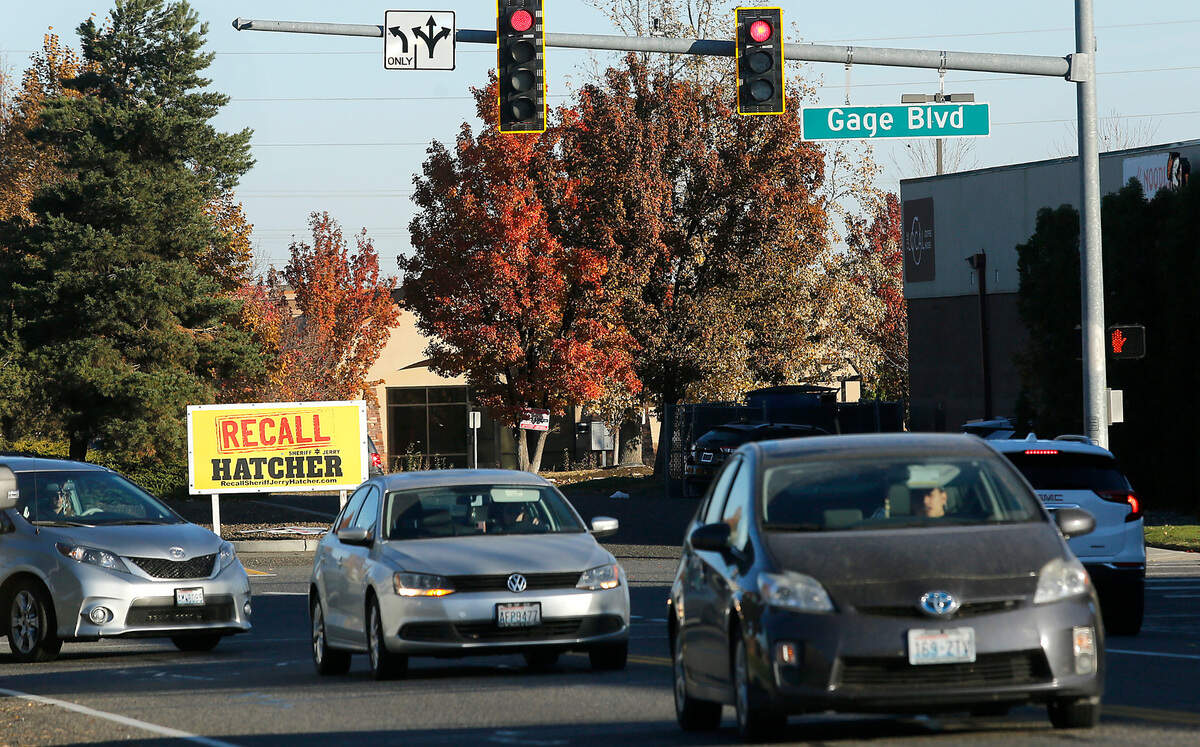 Motorists drive past a sign calling for the recall of Benton County Sheriff Jerry Hatcher on Gage Boulevard at the intersection with West Grandridge Boulevard in Kennewick.