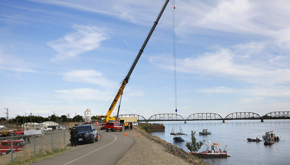 A crane on the Pasco shoreline pulls a floatplane that clipped and broke a power line that crossed the Columbia River to Clover Island on Wednesday afternoon is pulled from the river just below the cable bridge.