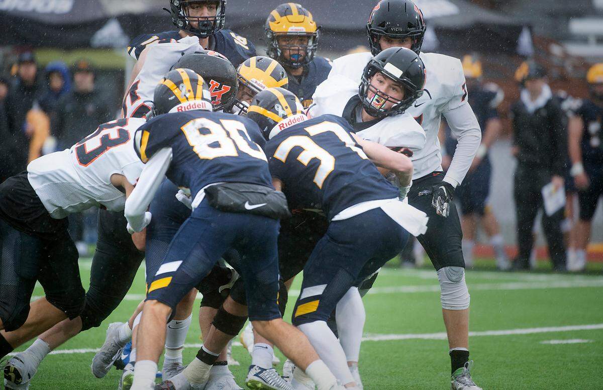 Kennewick senior running back Myles Mayovsky is wrapped up by Bellevue defenders Cal Zimmerman and Colin Miller during Saturday afternoon’s 3A football state championship game at Sparks Stadium in Puyallup, Washington, on Dec. 4, 2021. Bellevue won the title, 17-13.