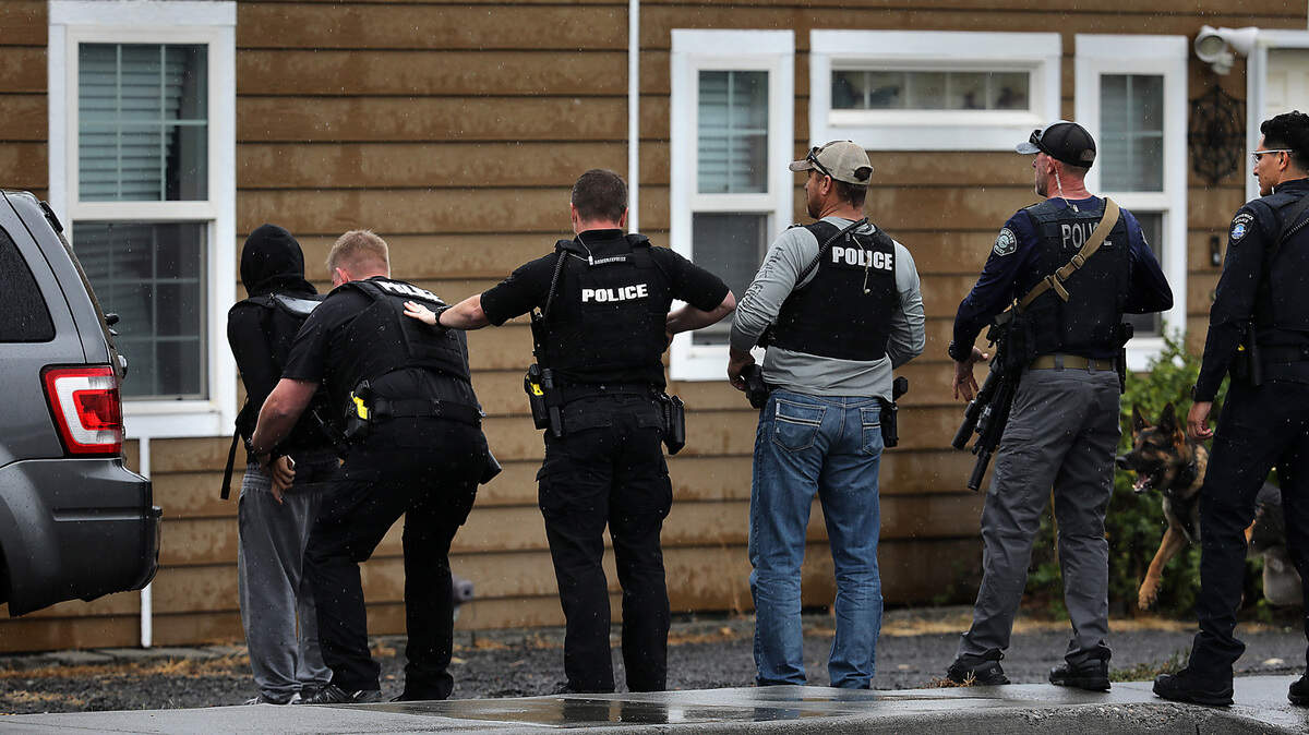 Police officers take one of two teens into custody in the 1800 block of West Fourth Avenue Wednesday afternoon in Kennewick. They were wanted in connection with a pair of robberies earlier this month, Commander Aaron Clem said. A group of Kennewick officers and Benton County deputies spotted the suspects near Fourth Avenue when a foot chase started.