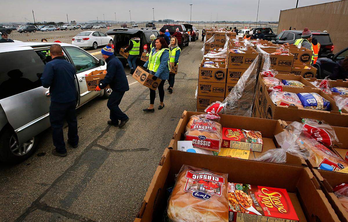Several dozen community volunteers team up to help distribute Thanksgiving meal boxes Tuesday at the Benton County Fairgrounds in Kennewick during Second Harvest’s 7th annual Turkey Drive event.