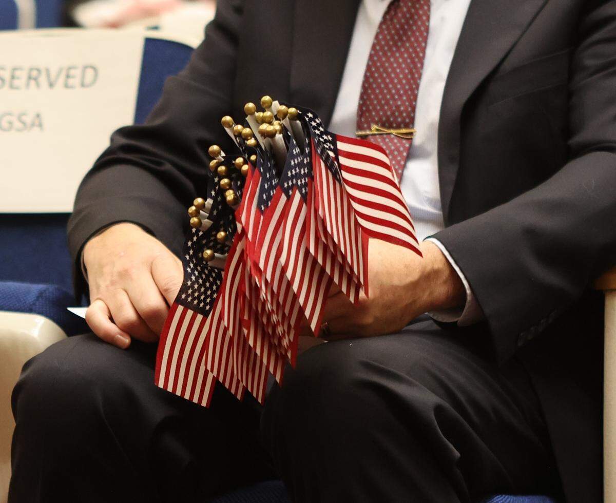 A court staff member holds 26 American flags to hand out to the new U.S. citizens at the U.S. District Court in Richland.