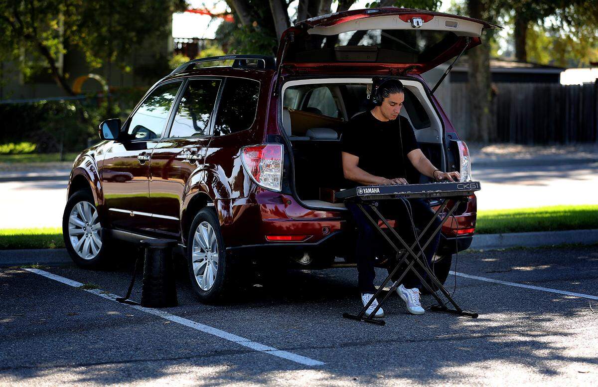As the morning temperature creeps up toward the predicted triple digits, Anthony Cuello, 34, of Kennewick, plays his battery-powered keyboard under the shade trees of the Kennewick Library on South Union Street.
