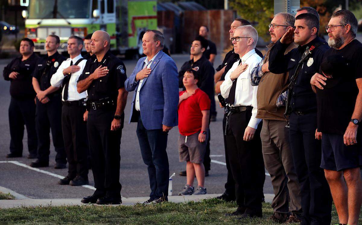 Firefighters, law enforcement leaders and community members cover their hearts as the national anthem is played at sunrise at the 9/11 memorial at the Southridge Sports and Events Complex in Kennewick.