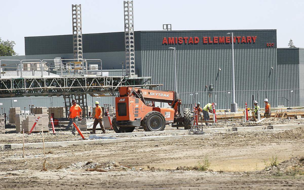 Construction workers and equipment work at Amistad Elementary School this past summer..