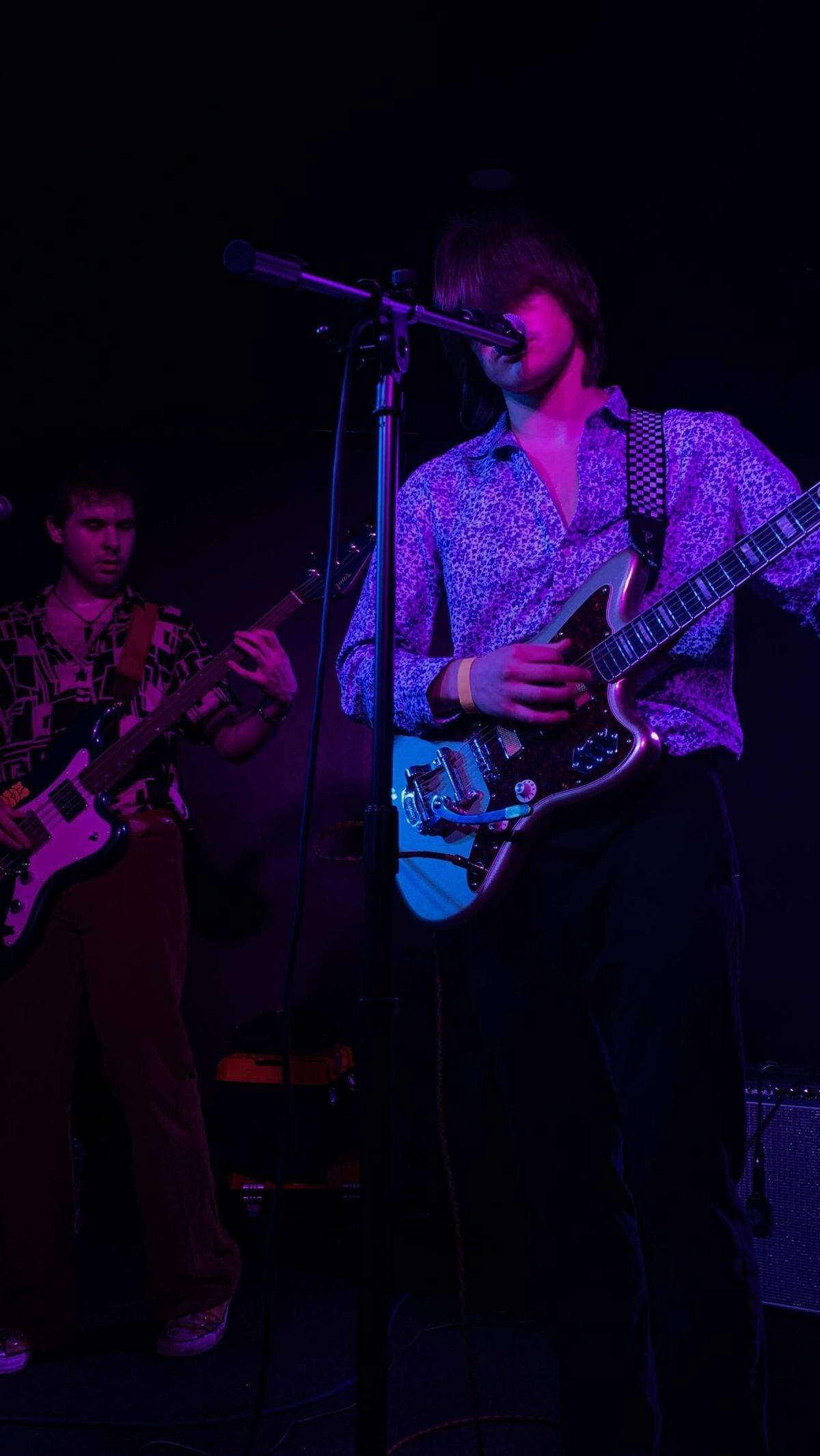 easyday’s rhythm guitarist and vocalist Chase Krank (right) sings into the microphone at Ray’s Golden Lion while bassist Griffin Durham (left) plays behind him on stage at Ray’s Golden Lion.