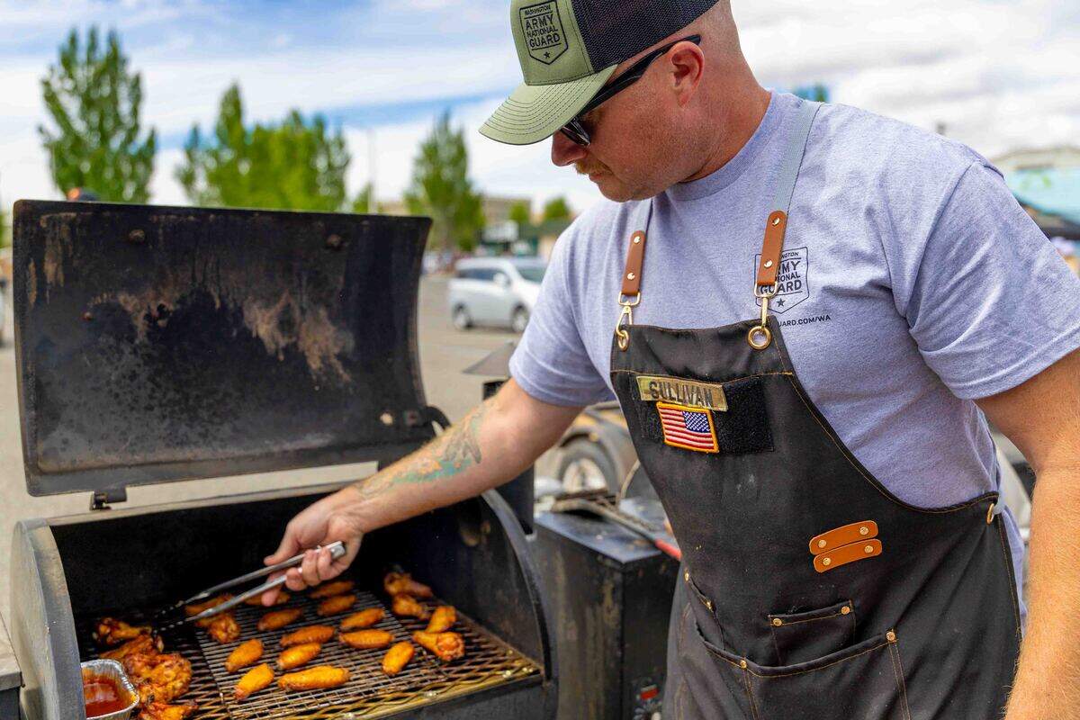 Sgt. 1st Class Joe Sullivan, a recruiter assigned to the U.S. Army Recruiting Station in Kennewick, grills chicken wings Saturday while representing the Washington Army National Guard during the Smoke & Shine BBQ Showdown at Cool Desert Nights in Richland. The barbecue competition was one of several featured attractions during the annual event.