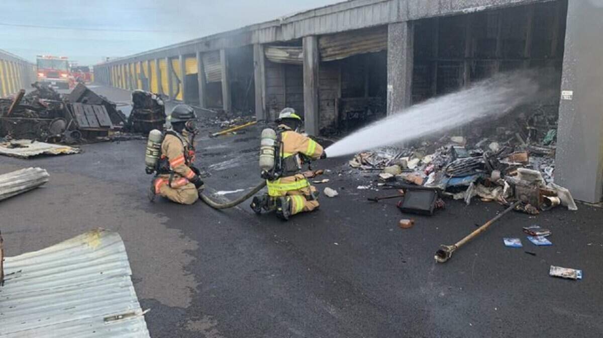 Fire crews shower a mini storage building with water Saturday morning, damaging several units.