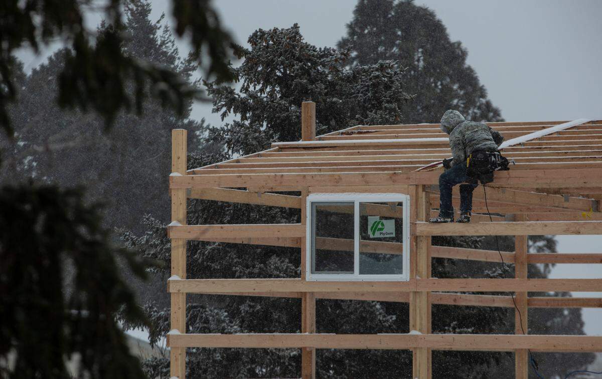 Leo Castaneda of Burbank works on a two-story garage in Kennewick as another bout of snow falls in the Tri-Cities.