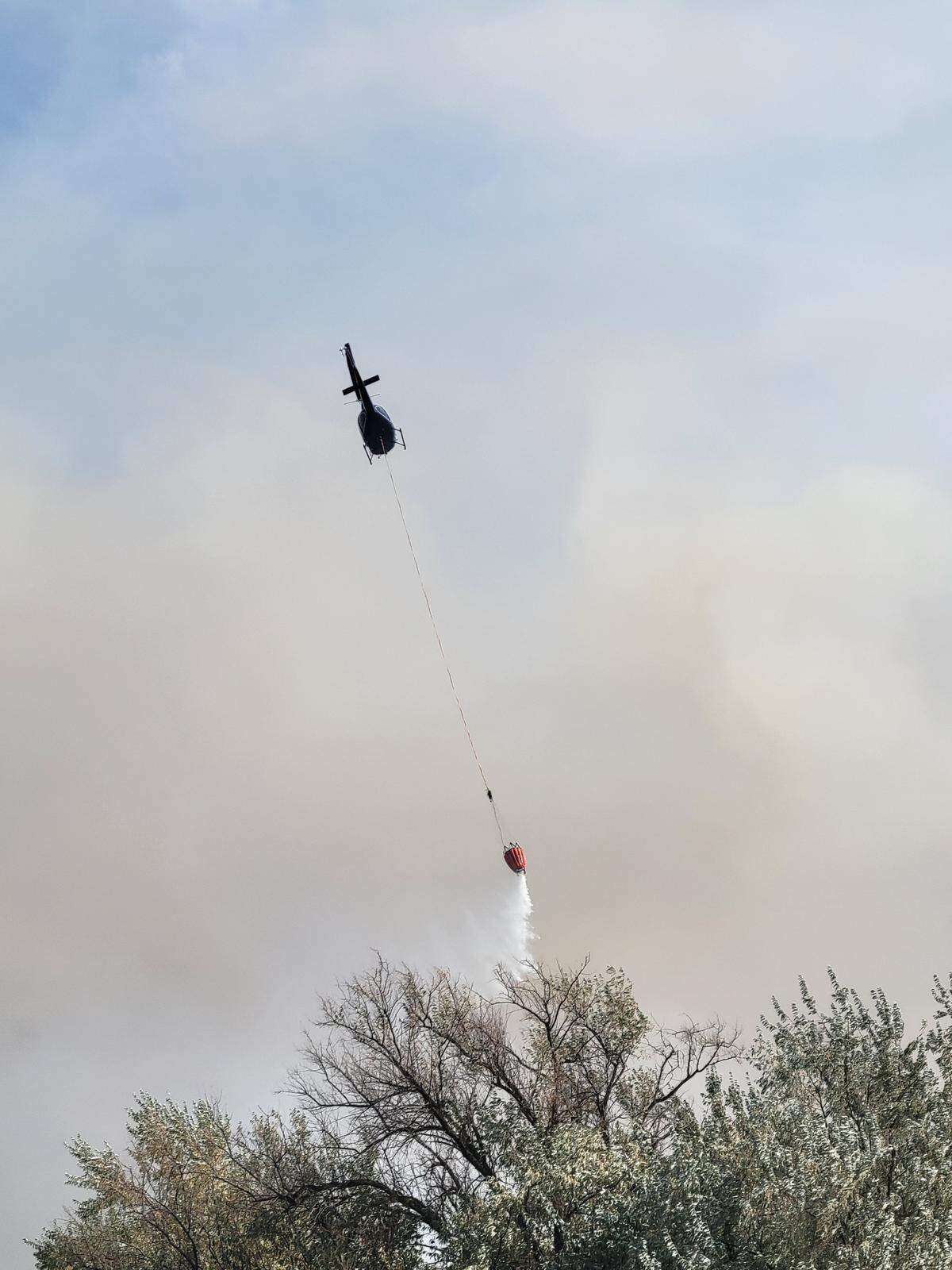 A firefighting helicopter used a bucket to douse flames on the Bensel Fire near Hermiston, Ore.