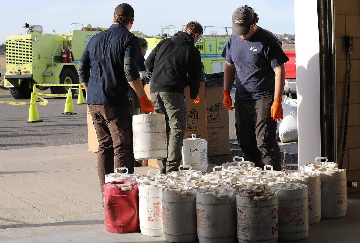 Workers from Clean Harbors Enviromental Services prepare to package and haul away aqueous film-forming foam from the Pasco Fire Department Fire Station at the Tri-Cities Airport.