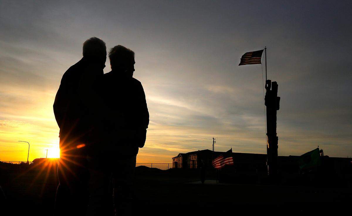Jeanette and Don Hummel of Kennnewick stand together as a member of Tri-Cities Professional Firefighters Honor Guard stands watch at the 9/11 monument.