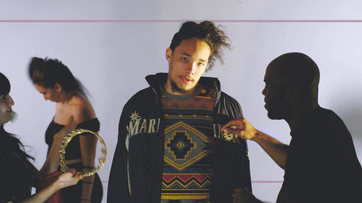 At the end, the video quickly cuts from black and white to color. As Nobi raps about wanting unaffordable material goods, people robotically rush around him at parties and photo shoots.