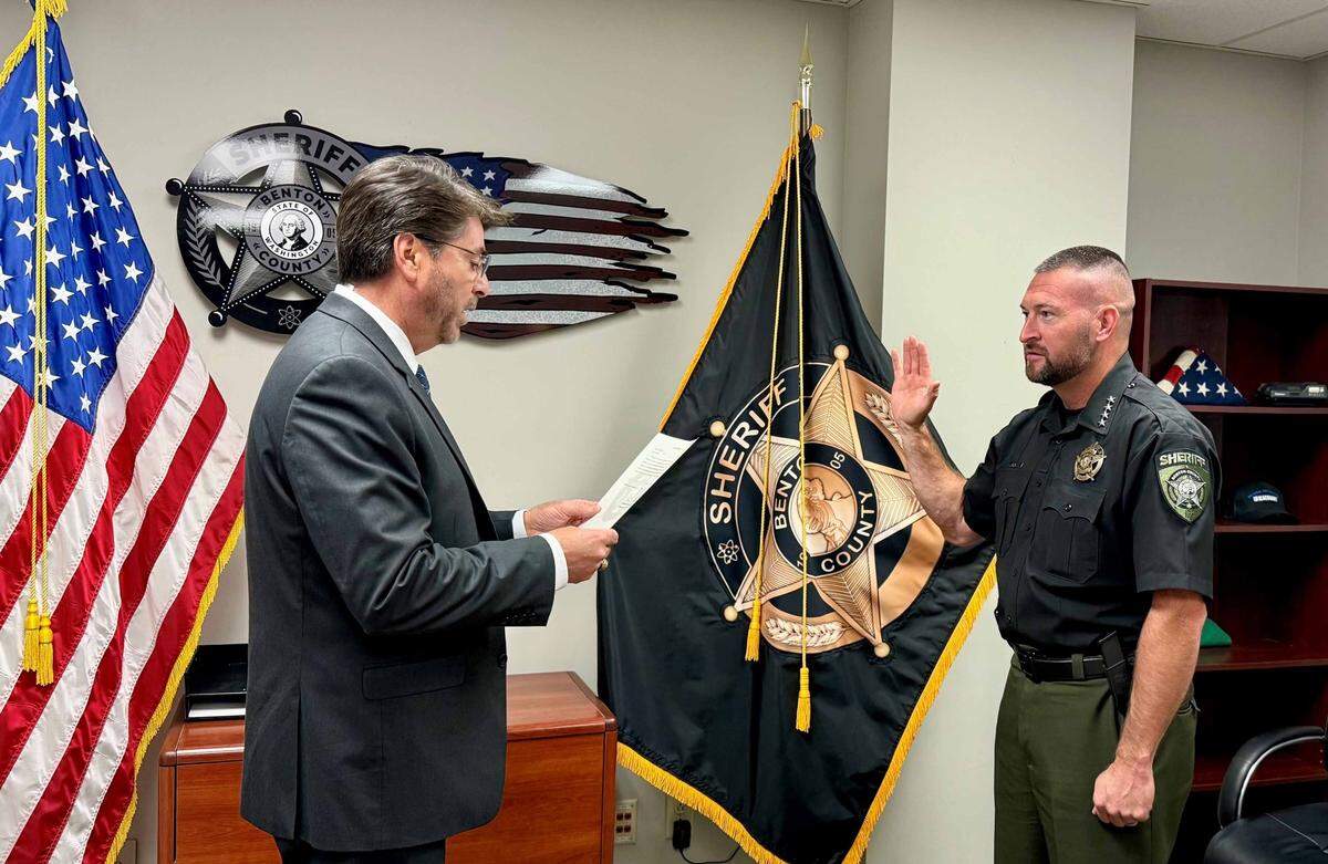Benton County Commissioner Michael Alvarez give the oath of office to Mike Clark after his appointment as interim sheriff.
