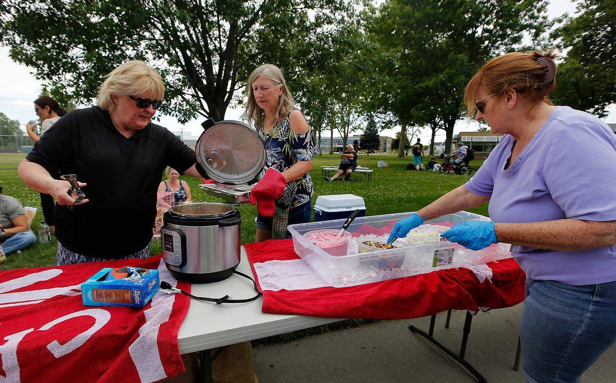 Volunteers Lana Franklin, Cindy Fish and Jenny Morse, from left, prepare to serve a free weekly meal to a group of homeless and others struggling in Kennewick in 2023.