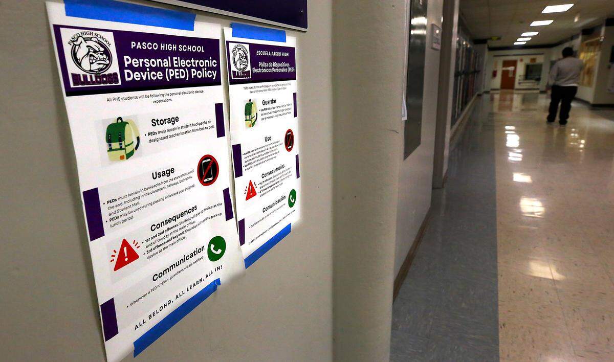 Bilingual posters with the Pasco High School Personal Electronic Device Policy are prominently displayed in hallways and classrooms throughout the school’s buildings.