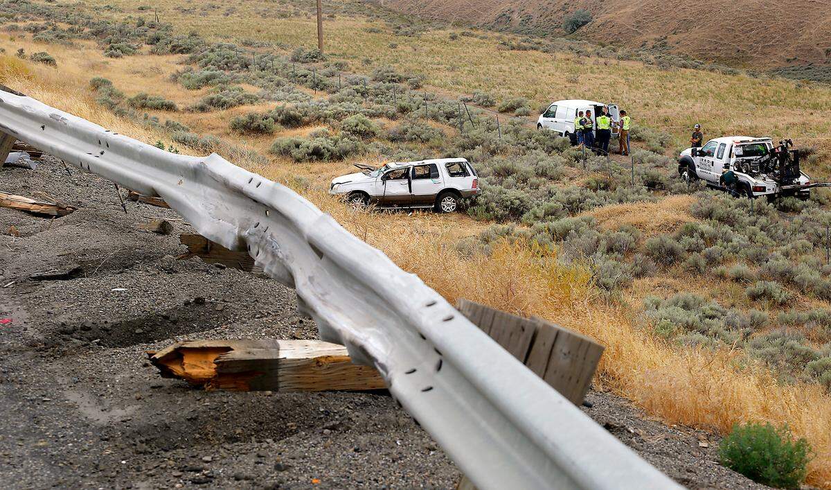 Tow truck operators from Rad Towing in Kennewick prepare to haul the heavily damaged Mercury Mountaineer involved in Wednesday’s double-fatal wreck near the Coffin Road exit on I-82 south of Kennewick back to town. The vehicle vaulted over a guard rail and rolled down the embankment.