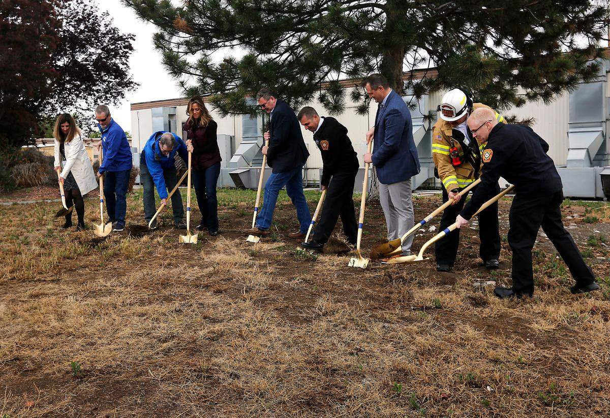 Kenenwick Fire Chief Chad Michael, far right, is joined Monday by firefighters, city officials and other dignitaries in the ceremonial groundbreaking for the new fire station one in downtown Kennewick. About 40 people attended the ceremony.