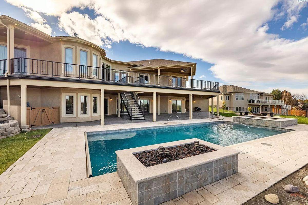 The backyard features a saltwater gunite pool with two waterfalls and hot tub.