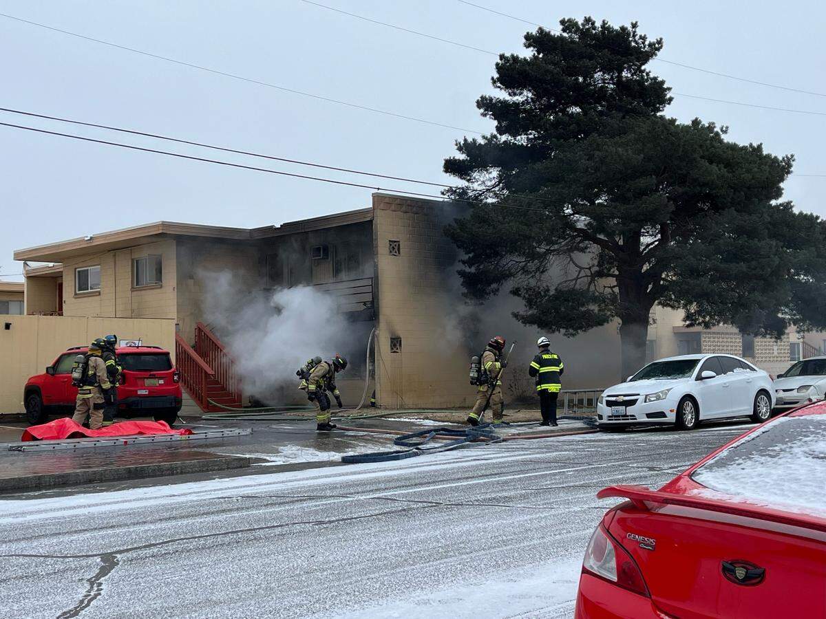 Pasco firefighters work to put out a fire in a Jay Street apartment building after it sent people inside out into the cold.