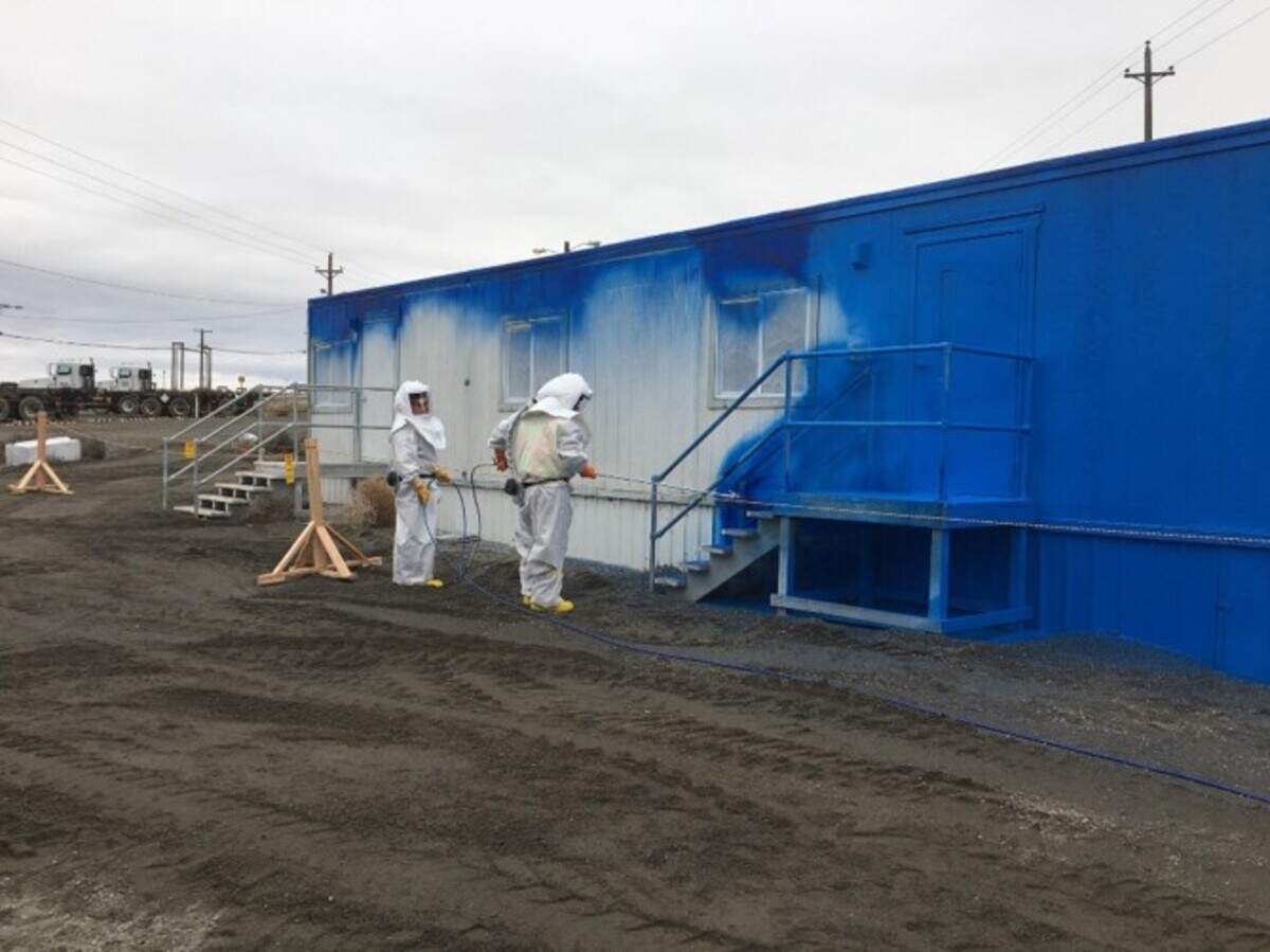 Blue fixative is sprayed onto an office trailer at Hanford after a spread of radioactive particles was discovered at the nuclear reservation.
