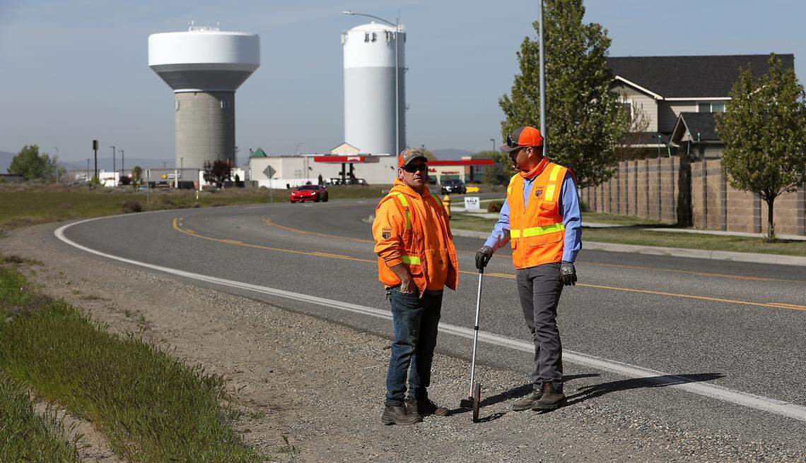 Pasco employees Mark Trumpy, left, and Victor Murillo, discuss measurements taken while preparing to install sign posts for new stop signs and warning signs for the intersection of Convention Drive and Sandifur Parkway in west Pasco. 