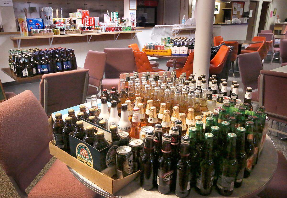 Dozens of expired bottles and cans of beer, soda and juices have been set aside on table inside the Kennewick Eagles club for disposal. The products were left unused after state government mandates closed much of the economy because of the coronavirus pandemic. It’s one of the financial losses the private club is suffering because of the shutdown.