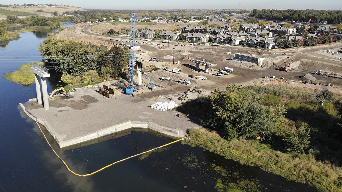 Crews work on the Duportail Bridge on Tuesday on the north shore of the Yakima River in Richland. They have until Sept. 30 to finish the foundation footings in the river to coincide with minimal fish and spawning activity. The temporary rock berm in the river is serving as a construction platform. The $38 million project is scheduled to open in 2020.