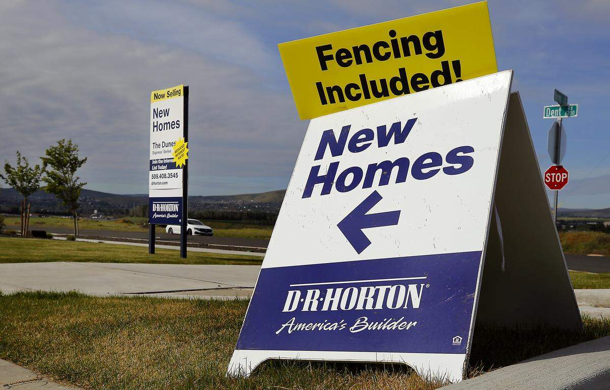 Signs advertise for new homes for sale in the The Dunes housing development in west Pasco.
