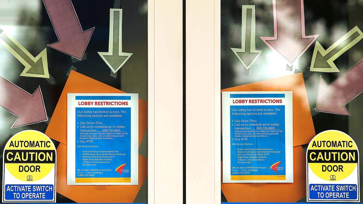 Various signs and numerous arrows point out the protocols for customers using the front door of the Banner Bank building on West Clearwater Avenue in west Kennewick during ongoing coronavirus pandemic.