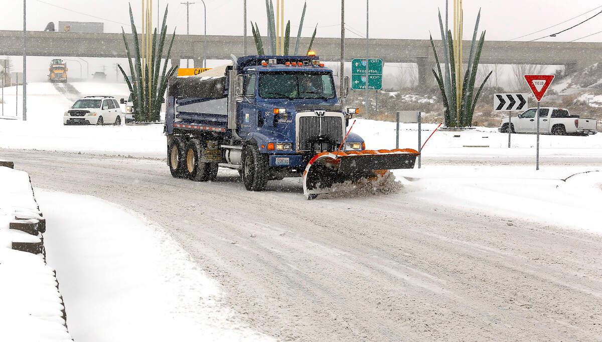 A city of Kennewick snowplow heads east on Clearwater Avenue from the roundabout near the Badger Road interchange for Interstate 82 in Kennewick.