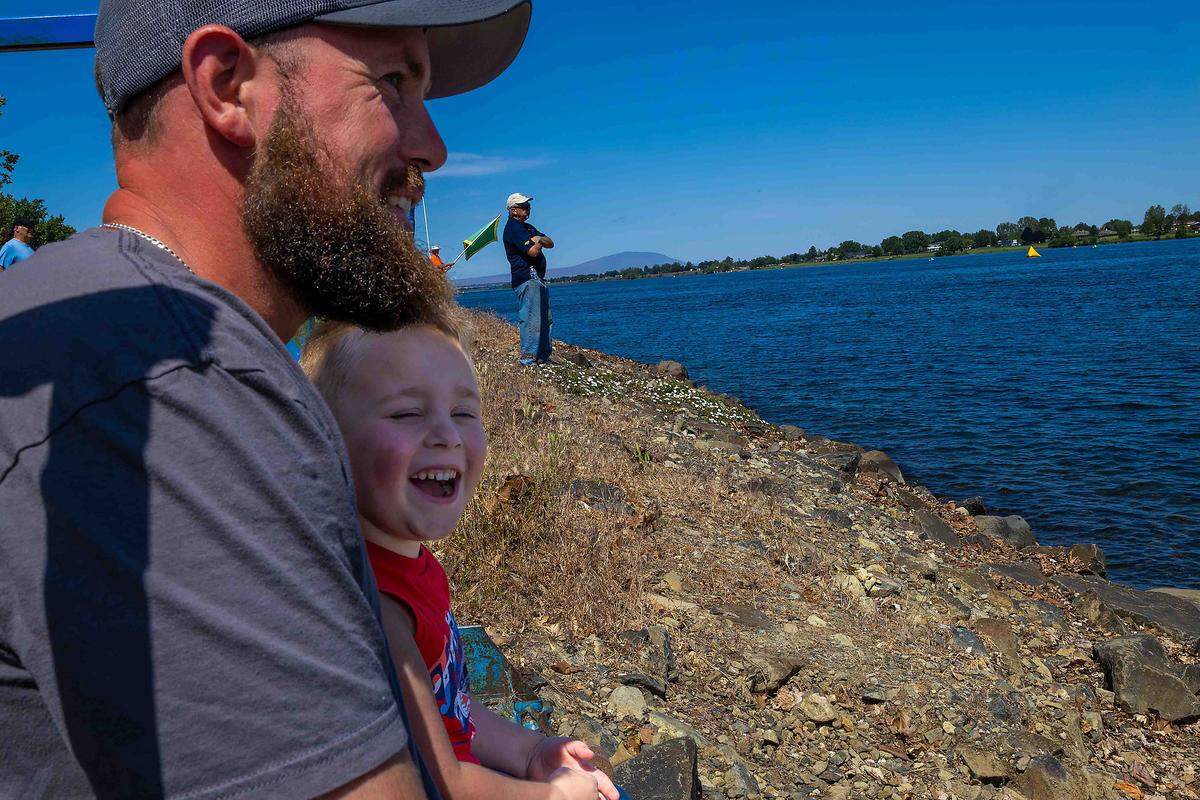 Gary Sather, left, smiles as his 4-year-old son, Josiah, reacts to hydroplane test runs on the Columbia River during spring testing on Saturday in Kennewick. Sather said he grew up attending Water Follies races and hopes to create similar memories with his son when the Columbia Cup returns in July.