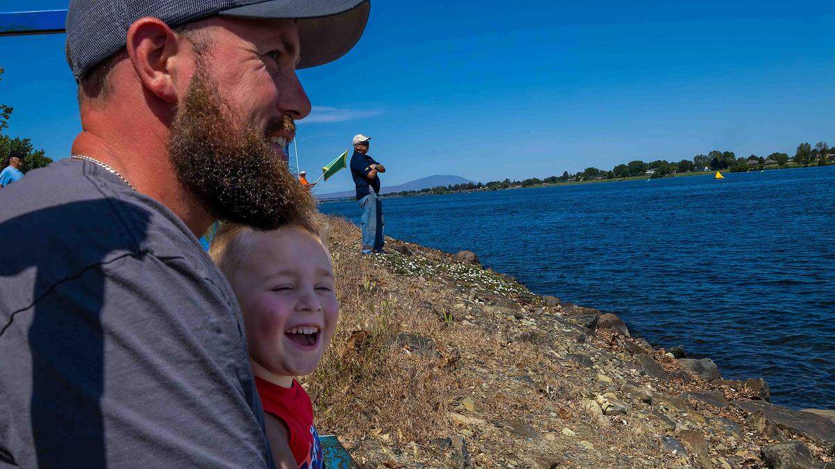Gary Sather, left, smiles as his 4-year-old son, Josiah, reacts to hydroplane test runs on the Columbia River during Spring Testing on Saturday in Kennewick. Sather said he grew up attending Water Follies races and hopes to create similar memories with his son when the Columbia Cup returns in Jul