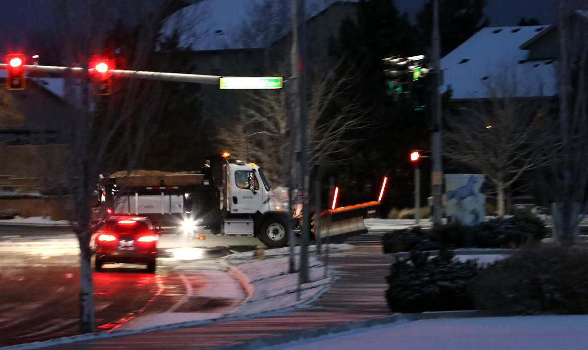 A city of Kennewick snowplow spreads salt in the intersection of Southridge and Hildebrand Boulevards early Wednesday morning following an overnight snowfall that is causing some school closures and delays.