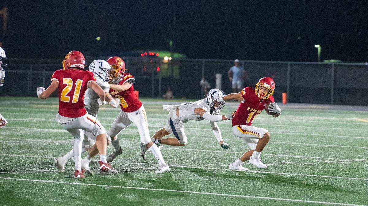 Kamiakin’s Fabian Hernandez breaks a tackle by a Chiawana High defender during the kickoff Sept. 2.