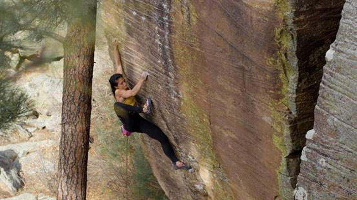 Nina Williams doing a high foot maneuver freeclimbing in Arizona