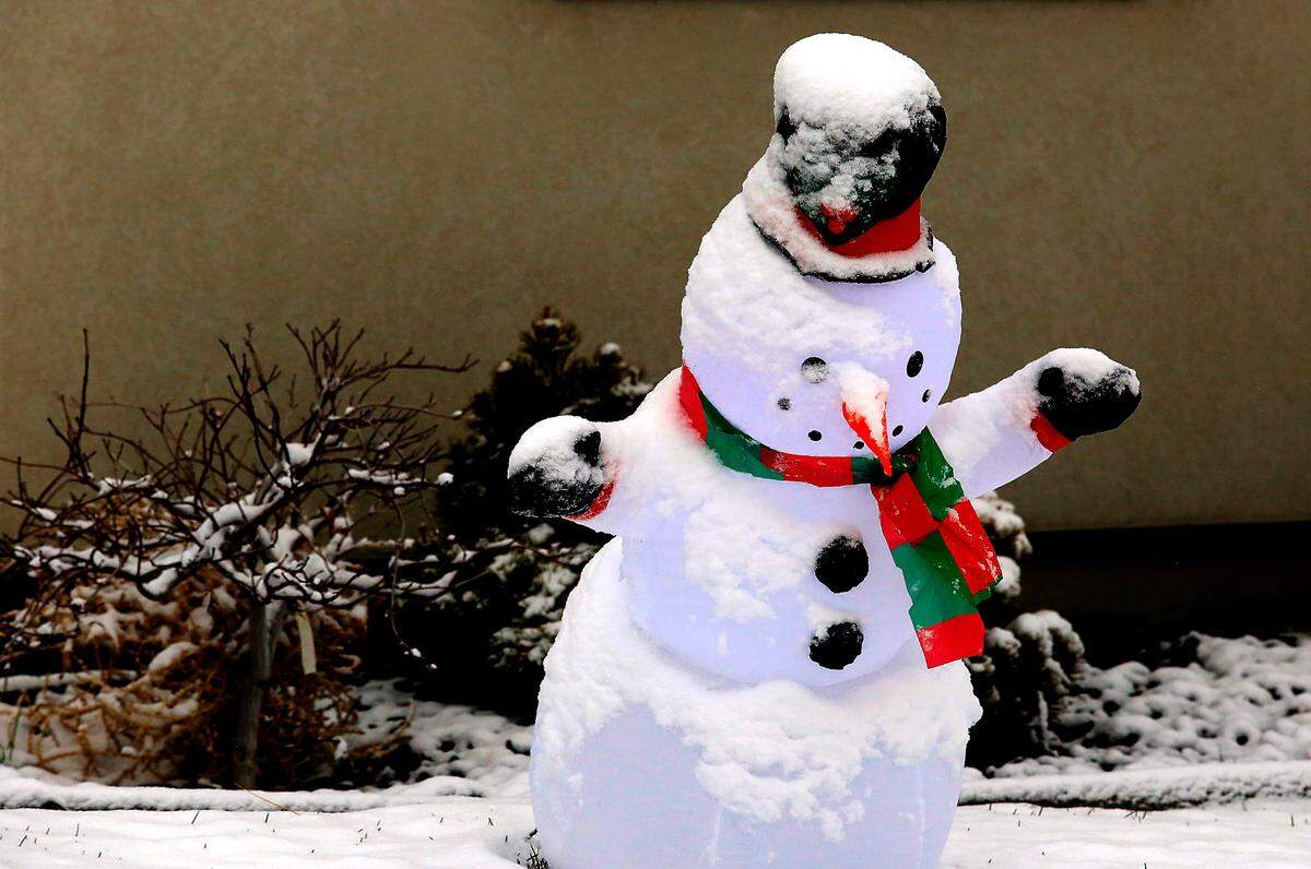 A Christmas snowman decoration wears a frosty layer of snow and ice in Kennewick.