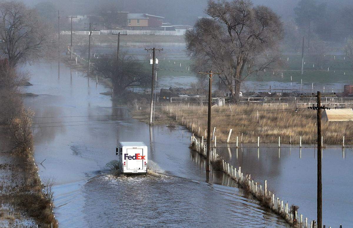 A FedEx delivery truck creates a wake Friday morning in the Yakima River floodwater covering Jones Road near Van Giesen Street in Richland.