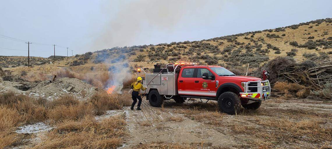 A firefighter works a brush fire.
