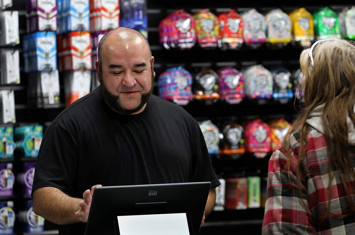 Employee Junior Jacquez rings up a customer at the new Lucky Leaf Co. cannabis store in Pasco.
