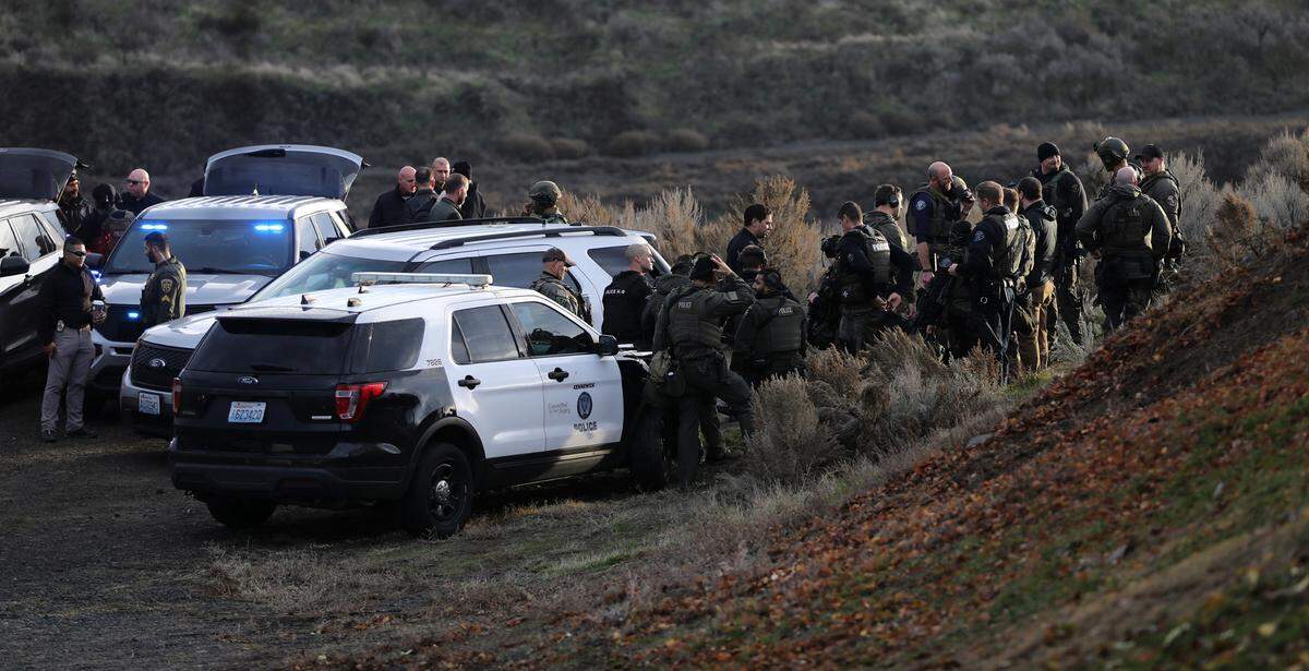 Members of the Tri-Cities Regional SWAT team and other officers gather after the body of Kennewick murder suspect Adam P. Klei was discovered in a ravine in east Kenenwick.