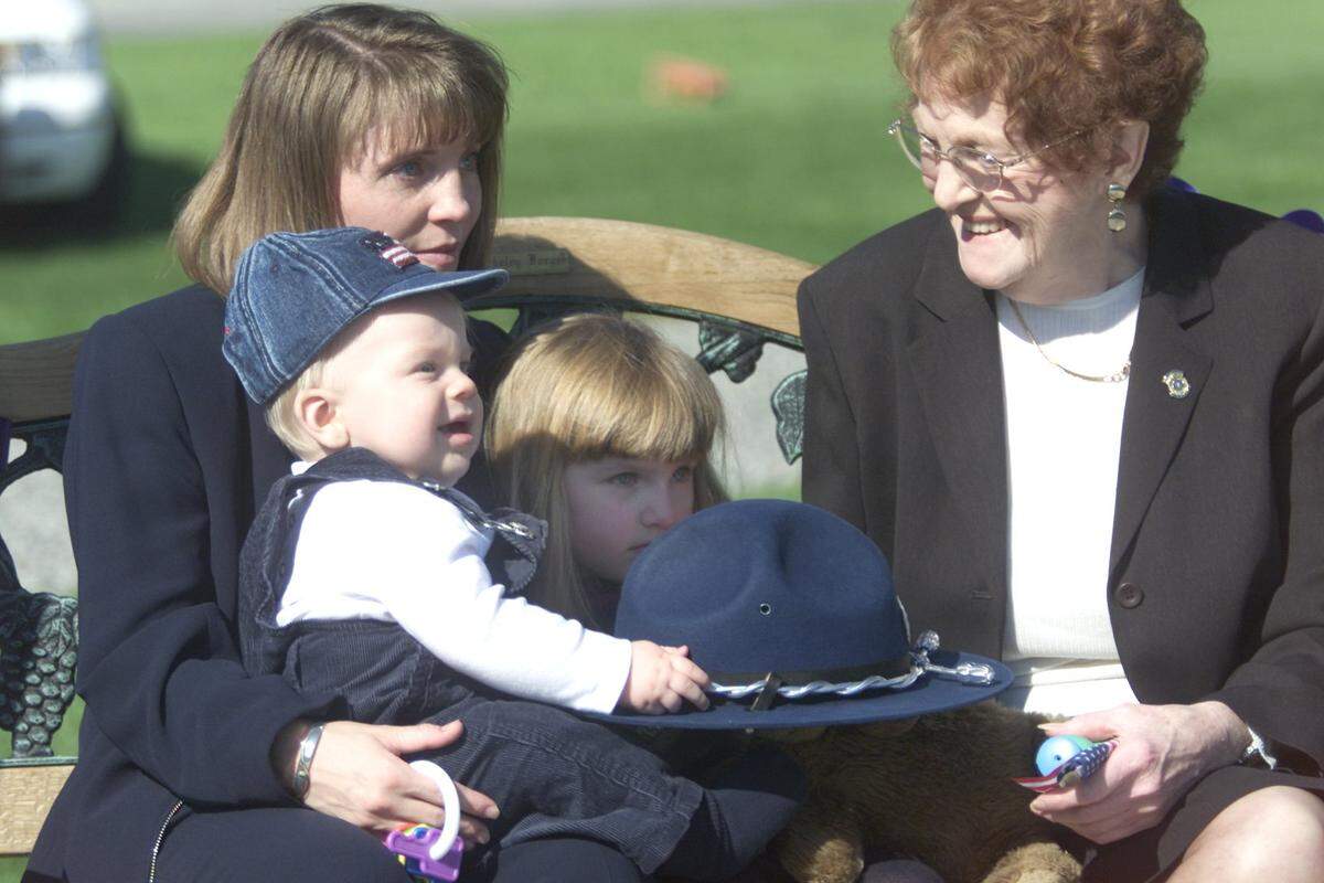 In this Oct. 7, 2000 file photo, Billie Saunders holds son, James Jr., 7 months, and Megan, 3, during a memorial for her husband, WSP Trooper James Saunders, who was killed on duty a year before. At right is Gloria Browning, his grandmother.