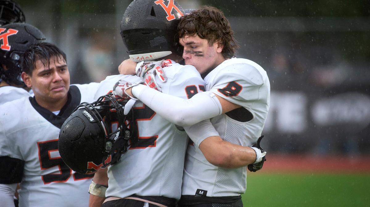 Kennewick senior wide receiver Simeon Howard (center) is comforted by sophomore teammate David Wacenske as time expires on the Lions’ 17-13 loss to the Bellevue Wolverines in Saturday’s 3A football state championship game in Puyallup. At left is senior lineman Santos Flores.