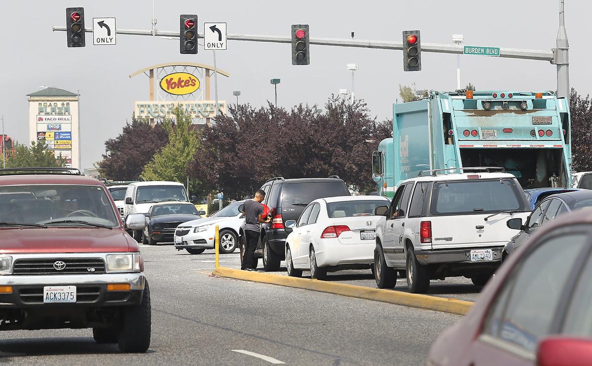 A driver adds gas to his empty tank after he stalled in the northbound lane of Road 68 at Burden Boulevard in Pasco. Red light traffic cameras are being added at the congested intersection in an attempt to curb collisions.