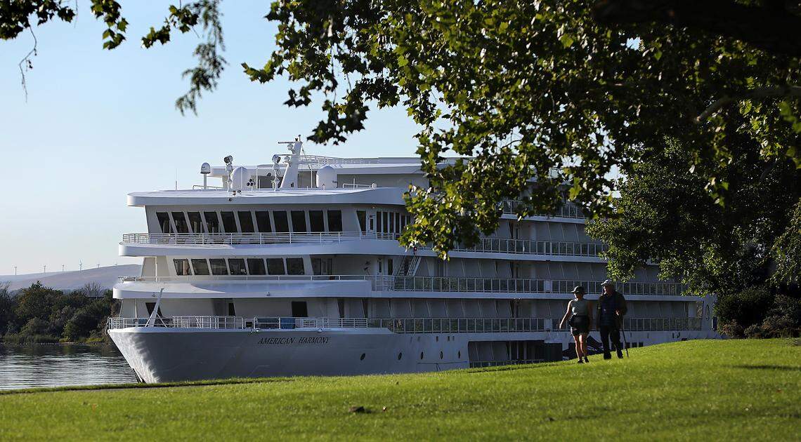 A pair of early morning walkers trek through Howard Amon Park past the American Harmony river cruise ship tied off at the Lee Boulevard dock on the Columbia River in Richland in 2023.